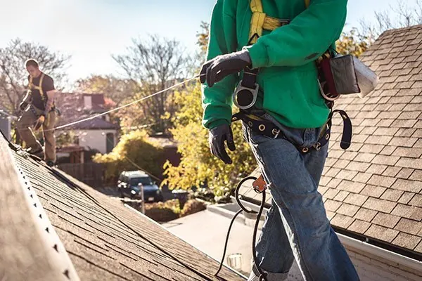 Roofer in a harness working on a pitched roof
